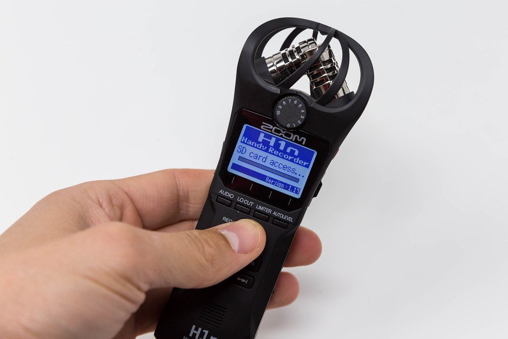 Close-up of hand holding the Zoom H1n Handy Recorder while loading SD card