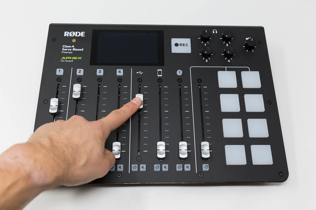 Hand adjusts the RØDECaster Pro, the world's first fully integrated podcast production studio