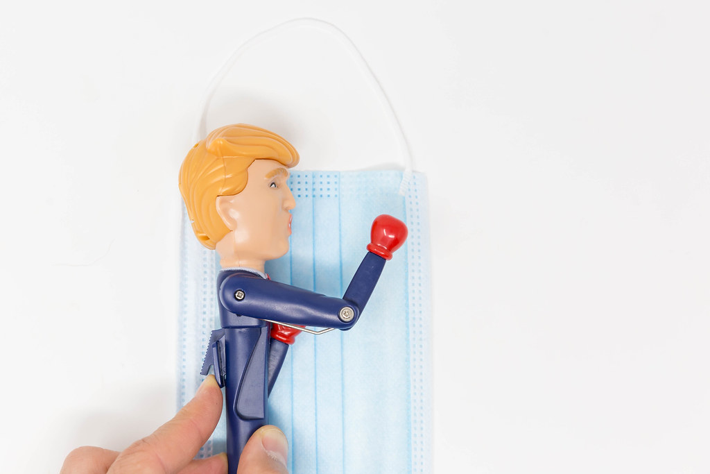 Trump and the Covid-19 crisis: US President stress relief pen with boxing gloves on surgical face mask