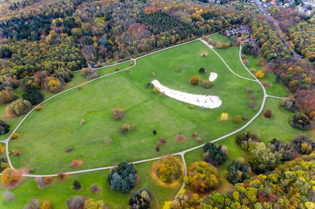 Aerial shot shows green park and forest during fall, for outdoor activities with kids and families, right next to the big city cologne