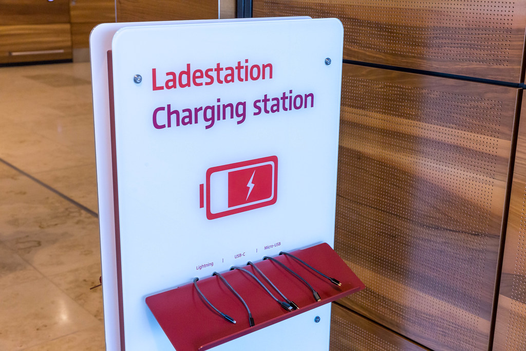 Ladestation für Handys und andere mobile Geräte mit verschiedenen Ladekabeln am Flughafen BER