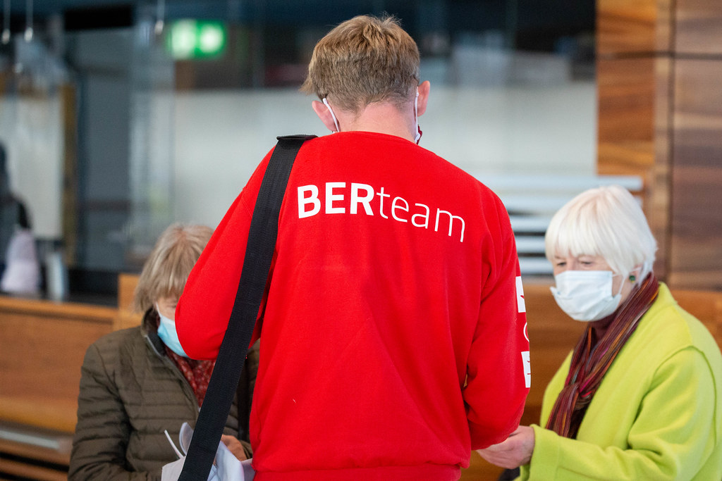 A BER airport employee wearing a red 