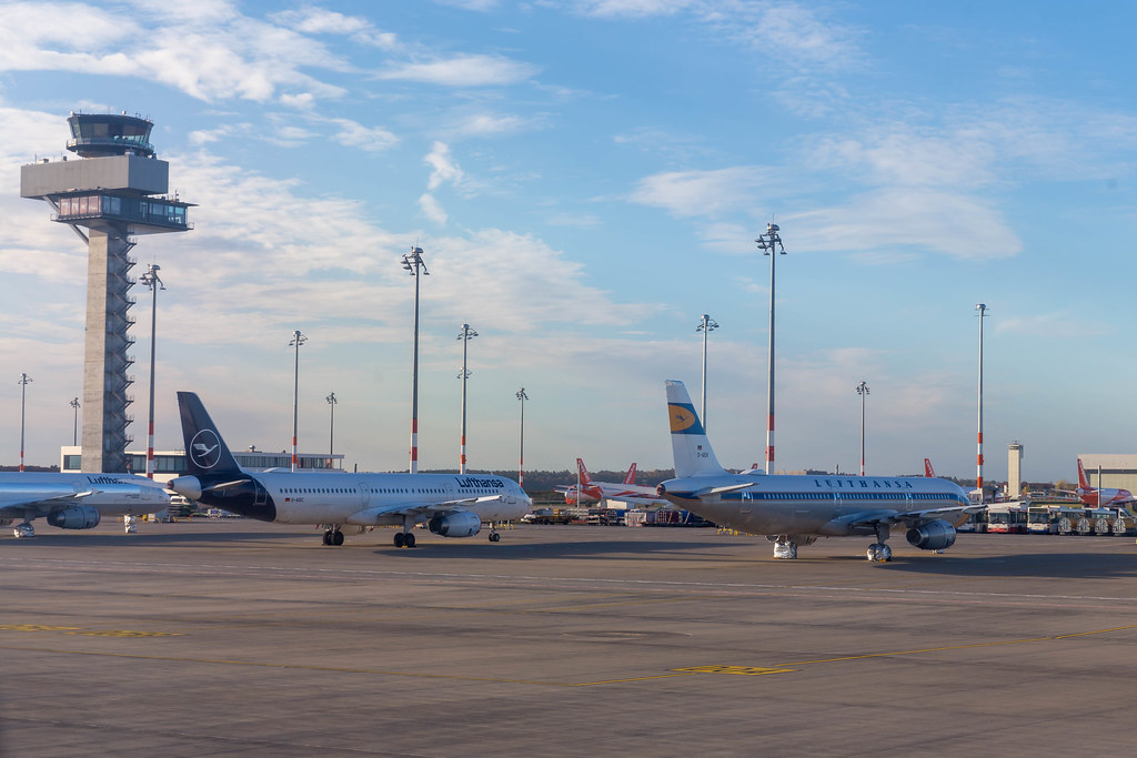 Flughafen BER: Lufthansa (im Vordergrund) und Easyjet Flugzeuge (im Hintergrund) mit Kontrollturm
