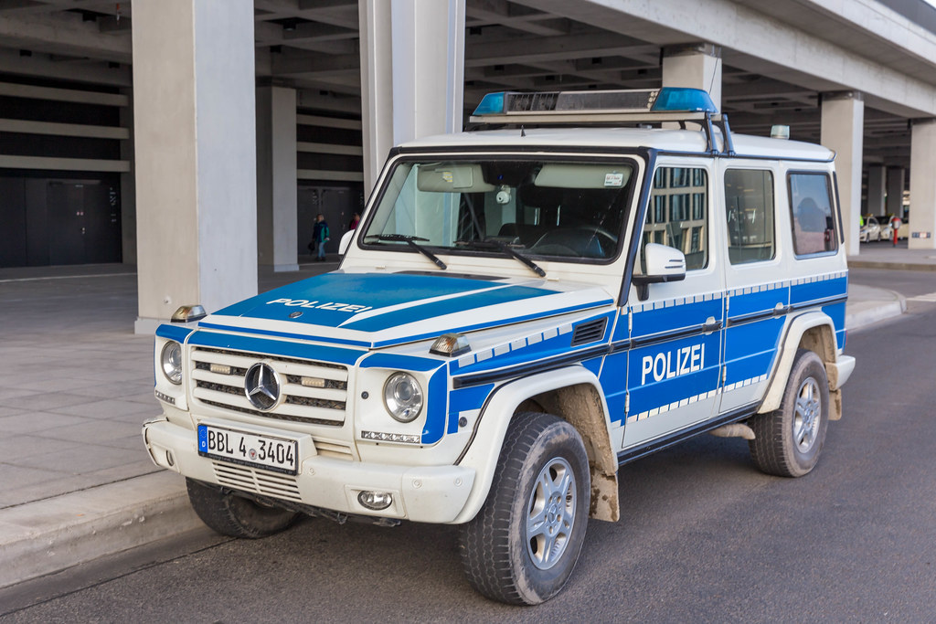 Ein großes Auto der Polizei in Berlin steht vor dem neuen Flughafen geparkt