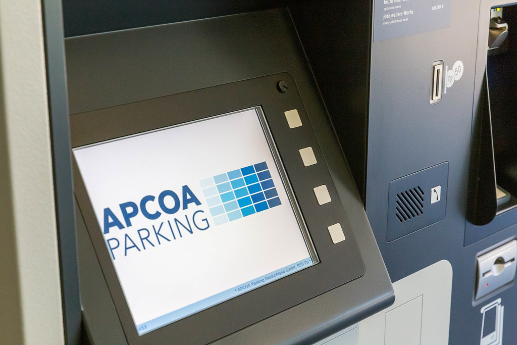 Screen showing the logo of APCOA Parking, European parking facilities operator, at BER airport