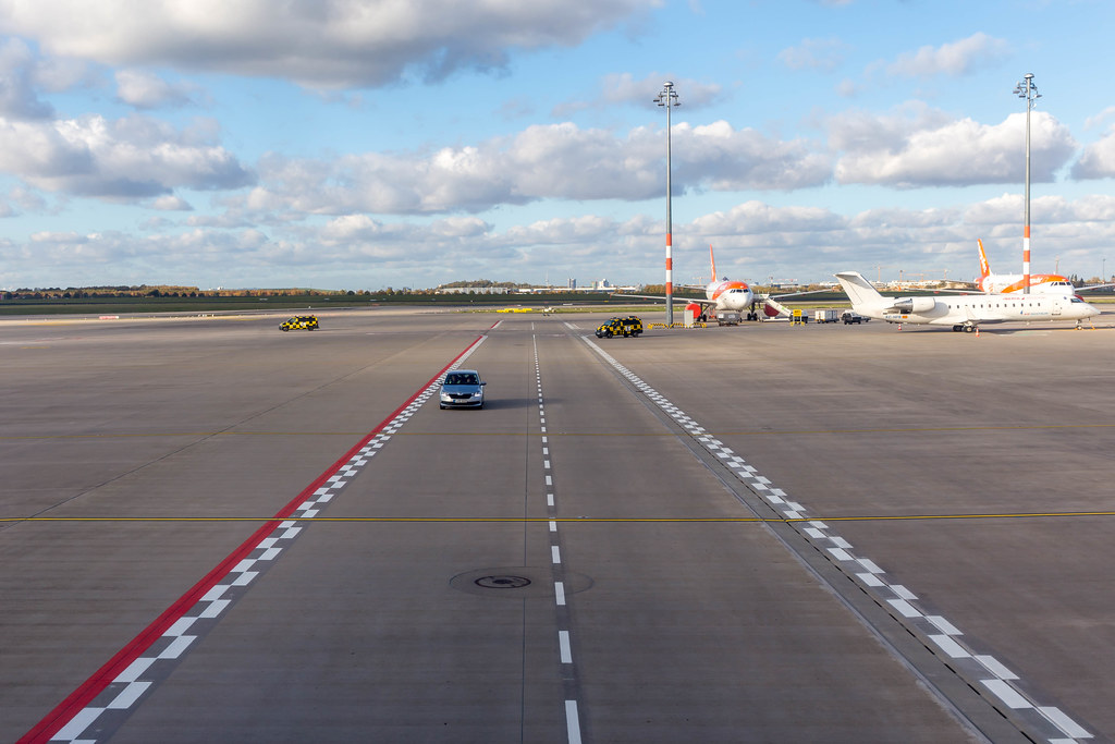 Auto auf der Rollbahn und Vorfeld mit Flugzeugen am neueröffneten Flughafen BER in Berlin