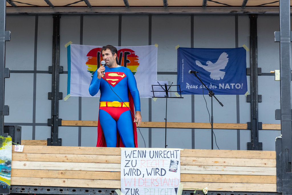 Mann in Superman-Kostüm verkleidet hält eine Rede auf der Bühne der 11.11. Querdenker-Demo in Köln