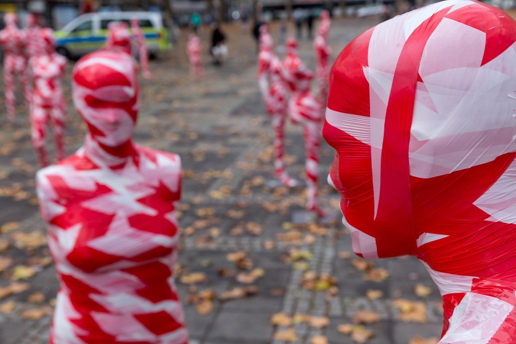 Covid-19 pandemic and art: two red and white mannequins facing each other at Neumarkt, Cologne