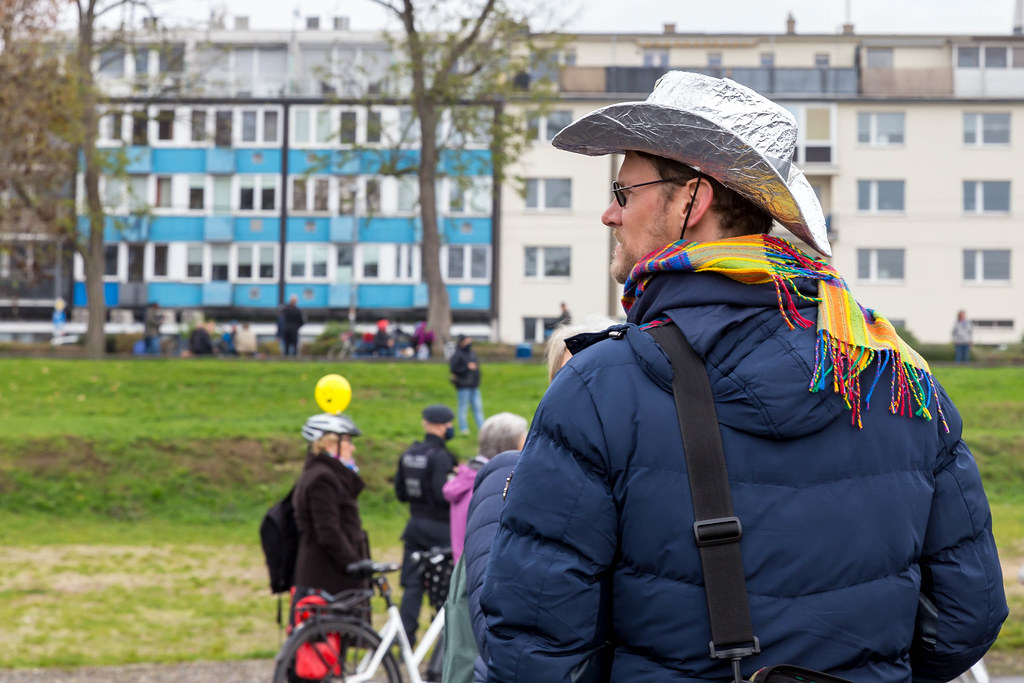 Mann mit Regenbogen-Schal und Aluhut und ohne Mundschutz bei der Anti-Corona-Demo in Köln