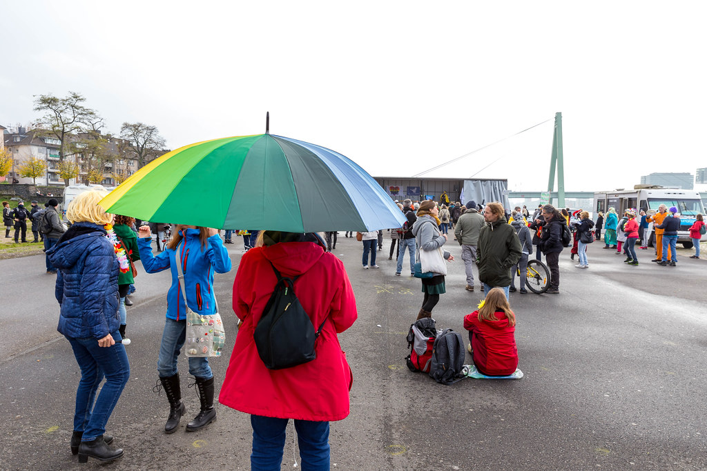 Woman with rainbow umbrella as symbol of peace at rally against anti-Covid measures in Cologne