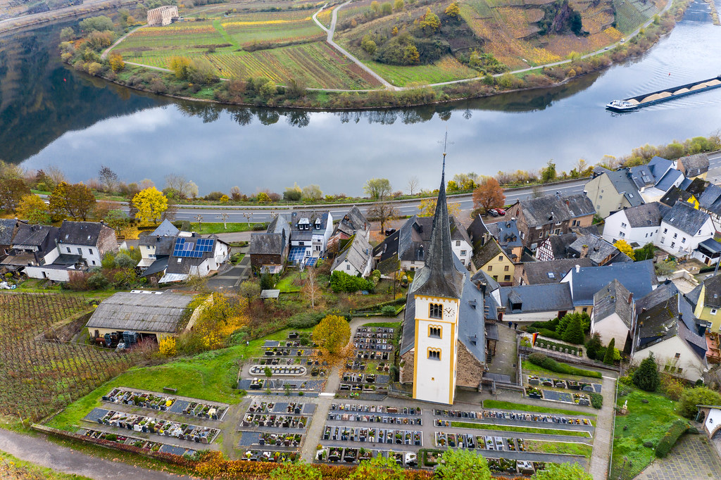 Drone Photo of Saint Lawrence Church with Car Parking Space and Residential Houses with River Moselle in Bremm, Germany