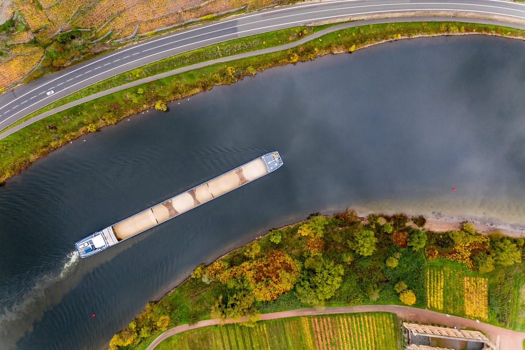 Bird View Drone Photo of Cargo Vessel loaded with Sand on River Moselle along a Highway and Kloster Ruine Stuben in Bremm, Germany