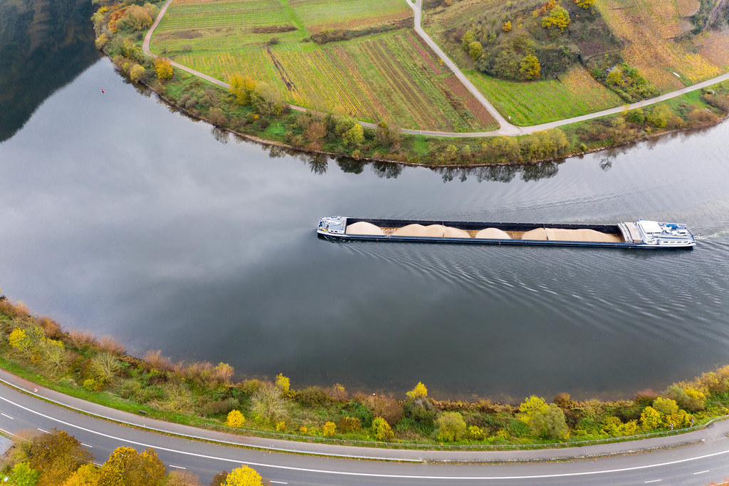 Aerial View of Cargo Vessel transporting Sand on River Moselle along Highway B49 in Bremm, Germany