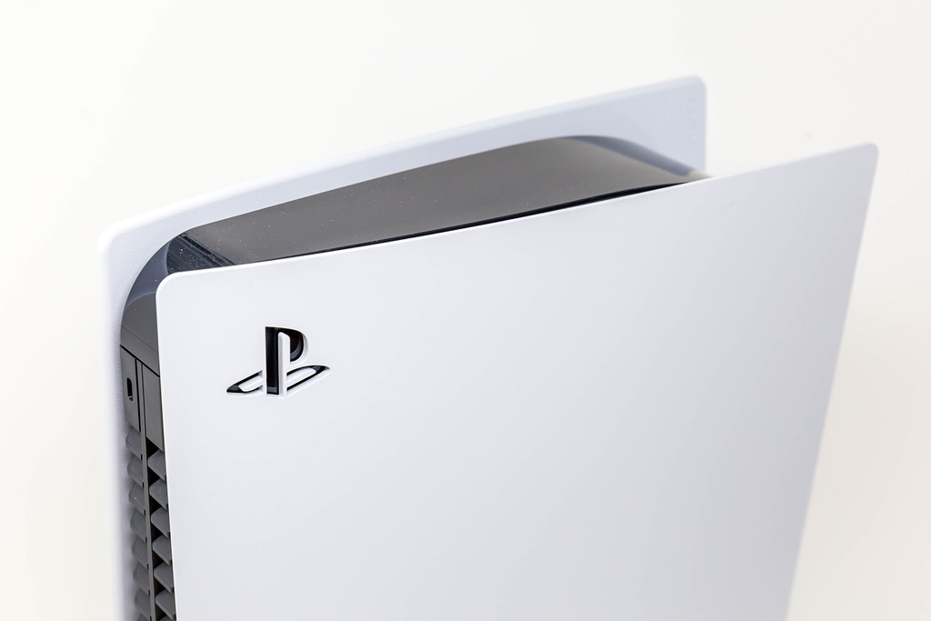 Close-Up Photo of Sony Logo on Upper Part of a Standing Sony PlayStation 5 on White Background
