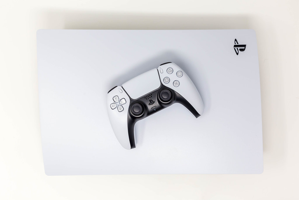 A new Sony PlayStation 5 Digital Edition with Sony DualSense Wireless Controller on Top with White Background