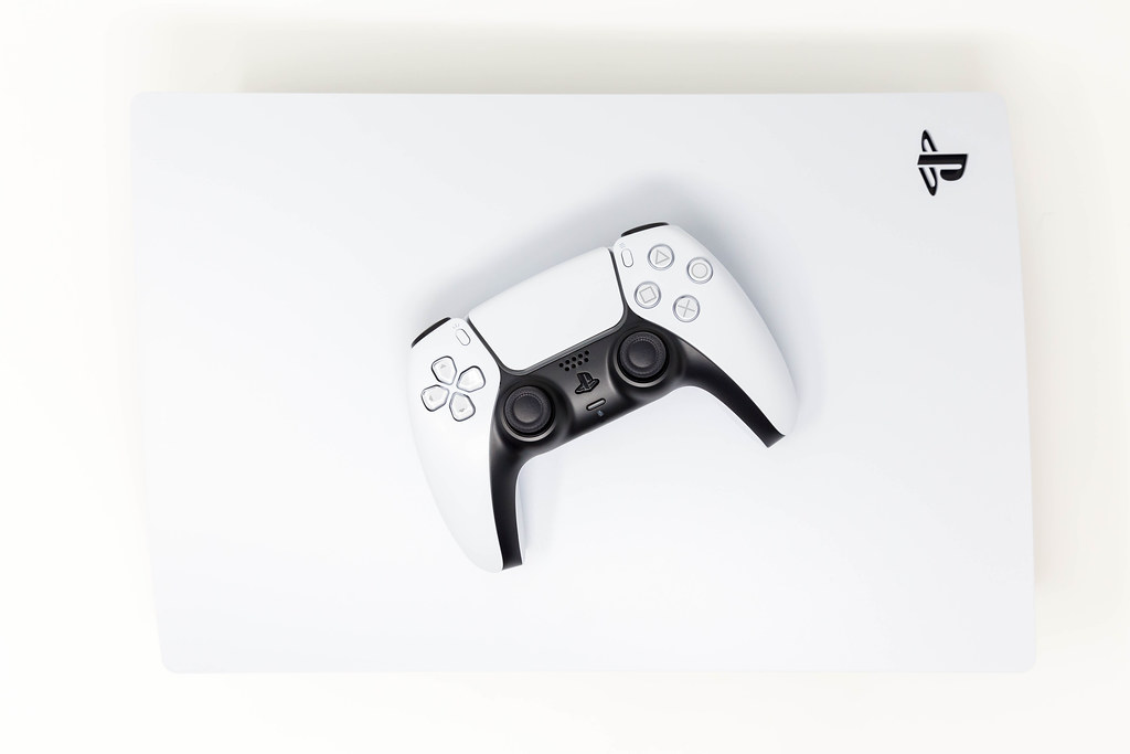 Top View Photo of Sony DualSense Wireless Controller on Top of new Sony PlayStation 5 on White Background