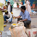 New Delhi, India - November 17, 2019: Street food vendor cooks and serves corn on the cob to hungry customers at Nehru Place market