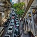 Traffic on Silom road with BTS Skytrain tracks above in Bangkok, Thailand