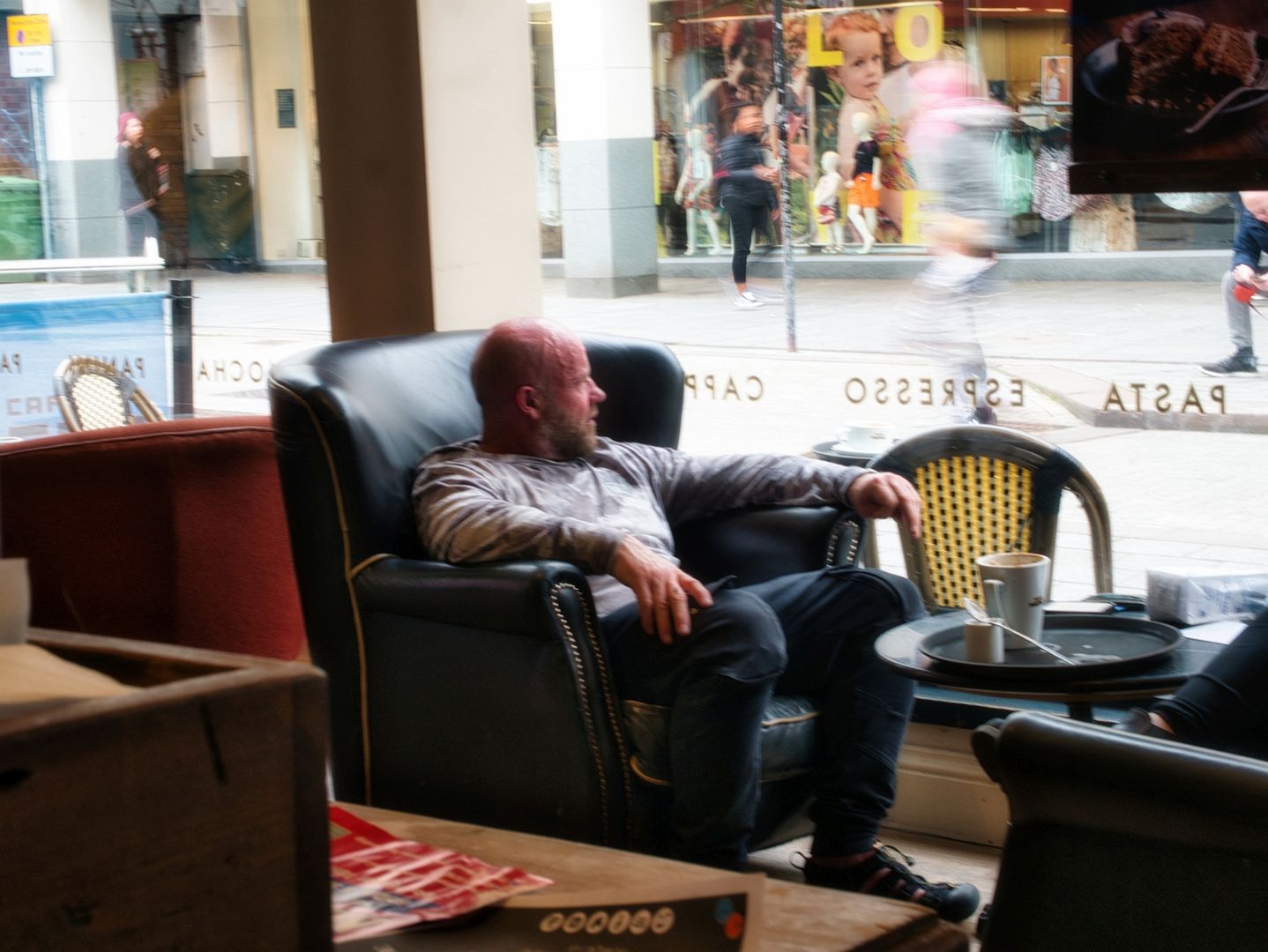Man in coffee shop watching people walk past. This image is provided on an as-is basis, royalty free for personal editorial, blogs and web display usage. - Candid Photography