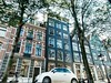 Car and buildings on the canal in Amsterdam. This image is provided on an as-is basis, royalty free for personal editorials, blogs and web display usage. - Royalty Free Urban Landscape