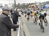 Man and others watching cycling road race. This image is provided on an as-is basis, royalty free for personal editorial, blog and web display usage. - Royalty Free People & Candid Situations