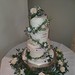 Three tiered semi naked wedding cake with flowers and foilage