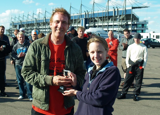 Andy Robinson receives trophy for 3rd in C at Rockingham from Emma Karwacki