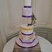 Four tiered purple gold themed wedding cake with a floating separator