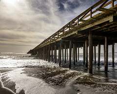 Surf, pier, sunshine and clouds