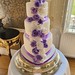 Three tiered heart shaped wedding cake with lilac and white sugar roses cascade