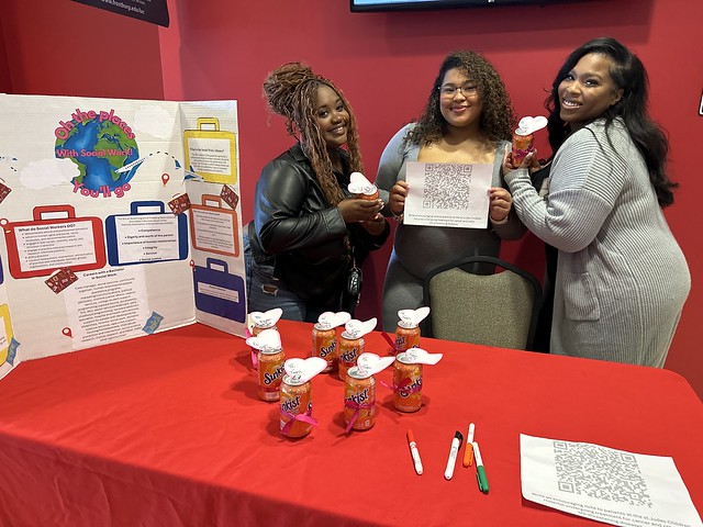 Amari Bolton, Aniya Mendoza, and Anya Benson of the Social Work Alliance give away soda and encourage people to write a card for a patient at St Jude’s hospital.