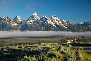 Wyoming, USA - June 26, 2020: Tourists take photos during a morning sunrise with a line of fog in the Grand Teton National Park in summer
